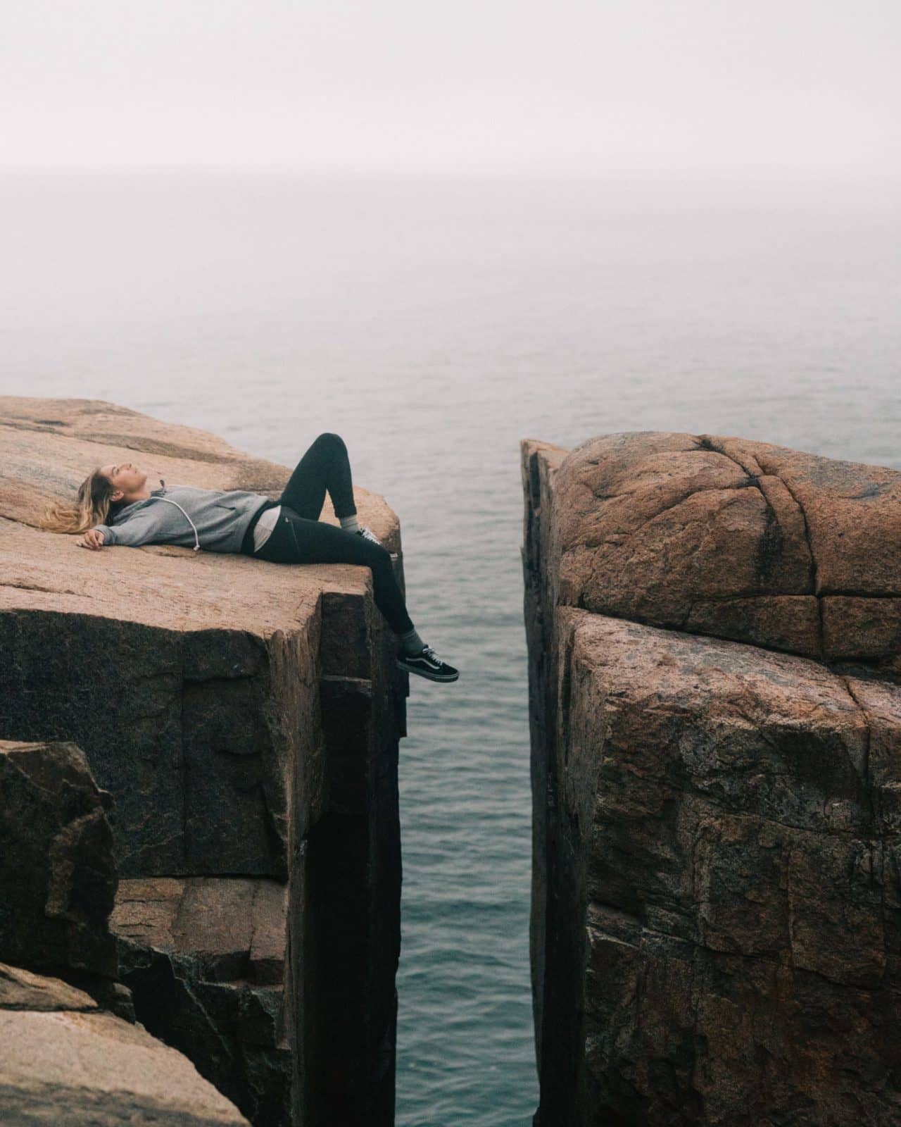 woman lying on top of cliff